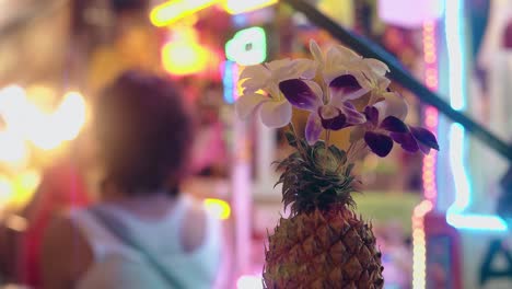 Reife-Ananas-Mit-Schönen-Blumen-Im-Nachtclub-Dekoriert