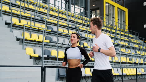 Glückliches-Sportliches-Paar,-Das-Im-Stadion-Spricht-Und-Zusammen-Läuft-1