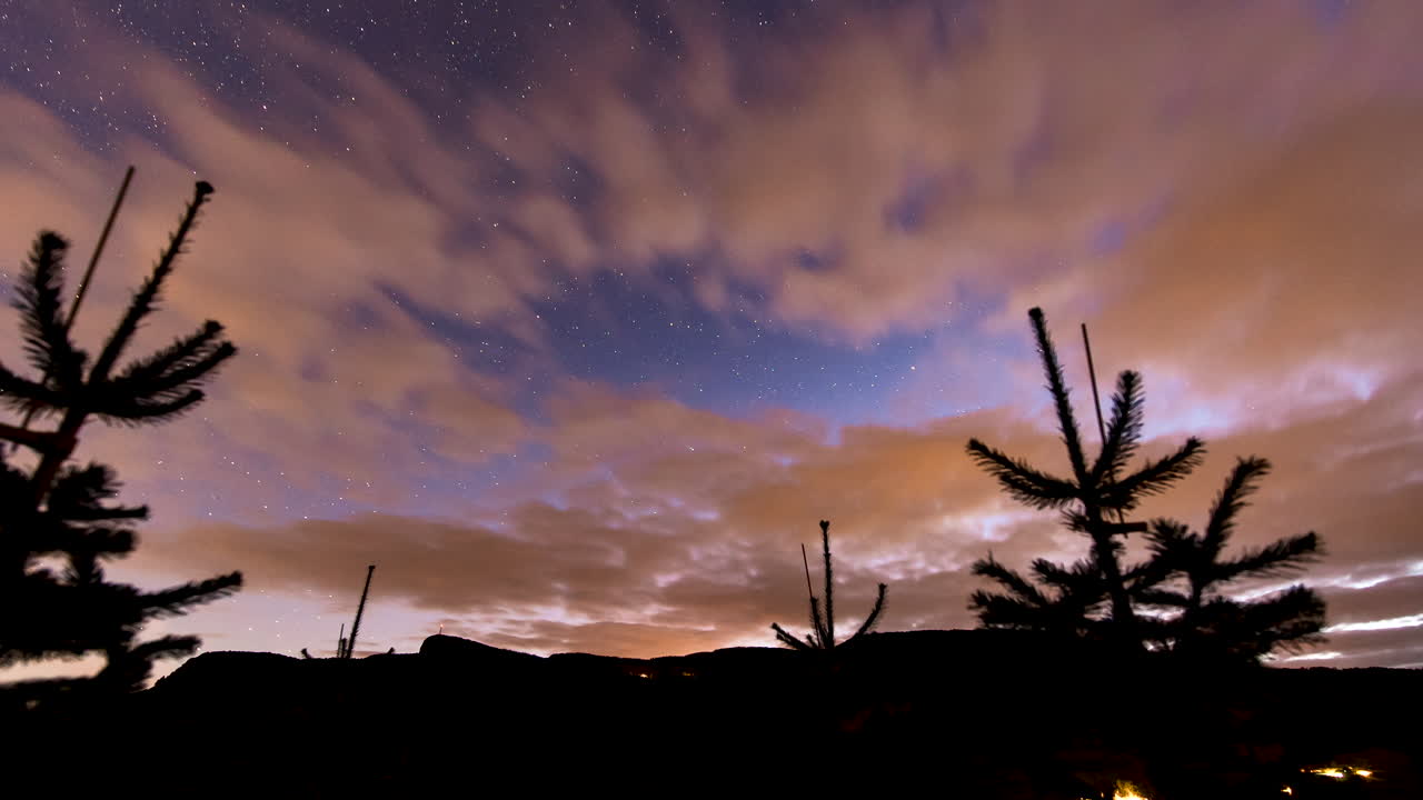 Night lapse of starry-night with orange-illuminated cloud movement; Scandinavia