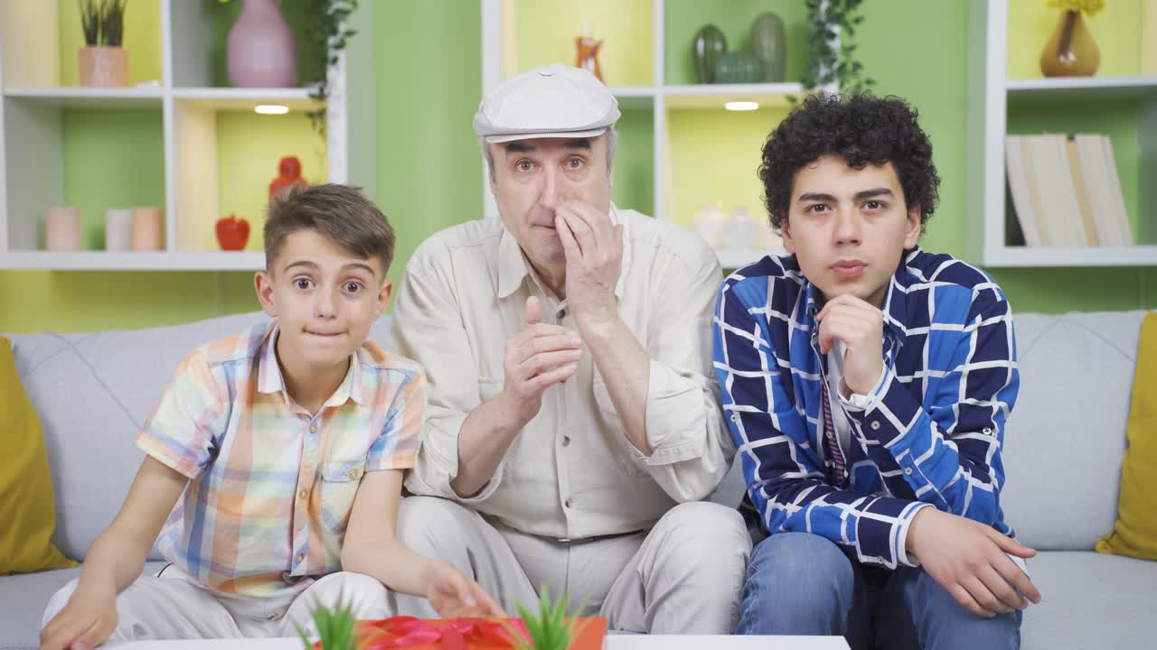 할아버지와 아이들은 놀랍게도 영화를 보고 있습니다.