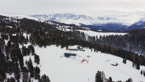 vista aérea de la zona de esquí de alpe lusia en italia durante un día de invierno nevado en italia