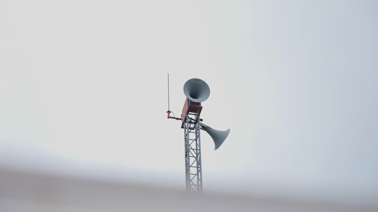 Filmato di una persona che fa un annuncio pubblico con un microfono in un contesto di villaggio. Mette in evidenza la comunicazione rurale, la messaggistica della comunità e gli eventi locali.