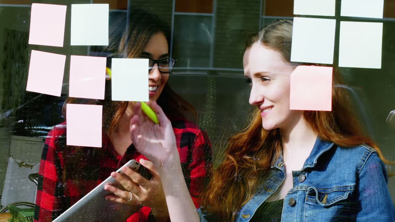 ejecutivas discutiendo sobre notas adhesivas