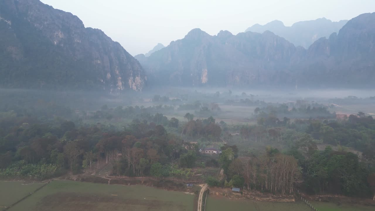 Ripresa con drone di una strada nella valle nebbiosa a Vang Vieng, la capitale dell'avventura del Laos.