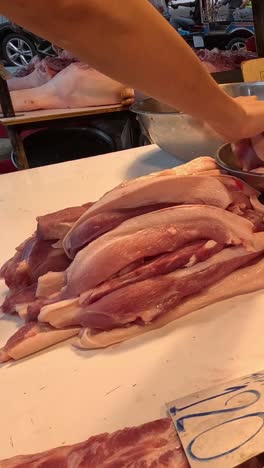 las manos del carnicero cortando y arreglando la carne