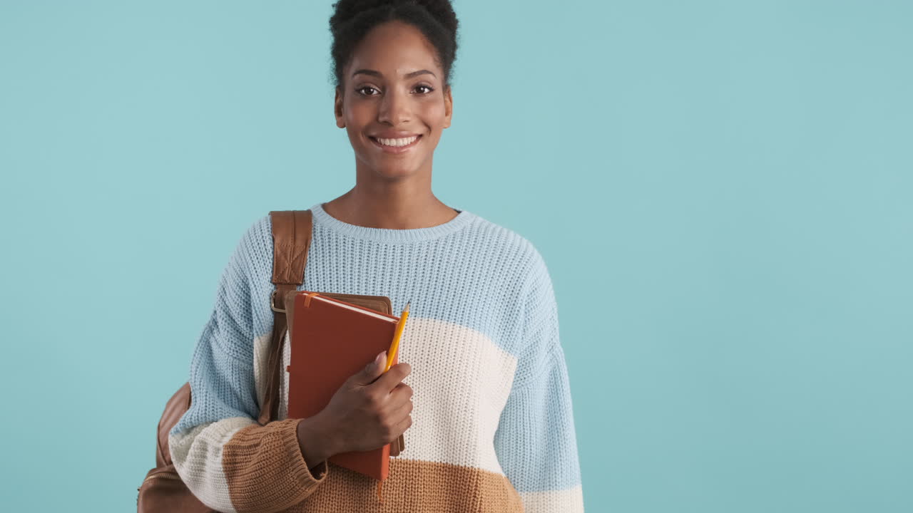 Attractive student walking with school supplies