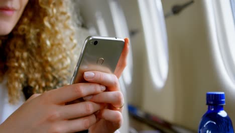 businesswoman using mobile phone in private jet 4k