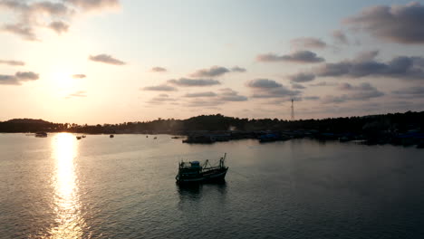 Aerial-Drone-footage-of-a-boat-during-sunset-near-an-island-in-cambodia