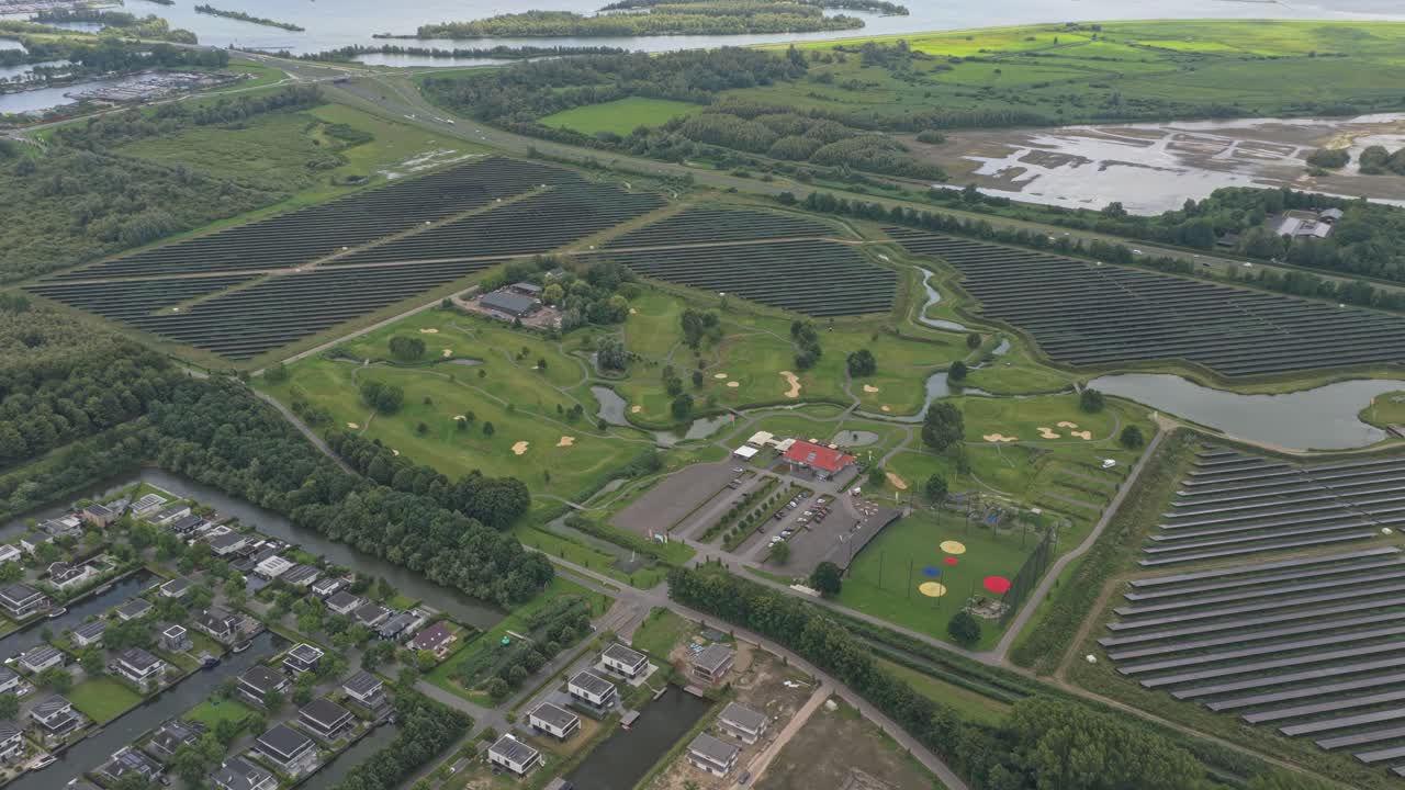 Aerial golf course, 18 holes and bunkers, solar farm nearby, Netherlands