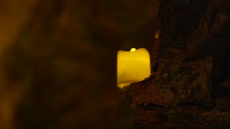 vela led brillante colocada en el borde de la pared de roca oscura durante la noche
