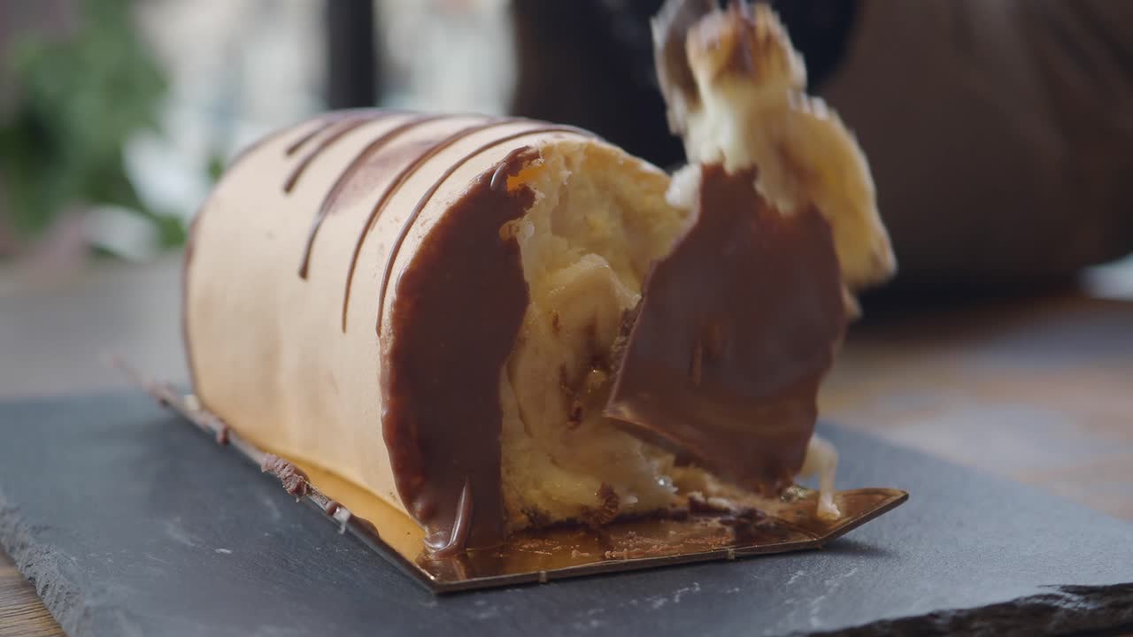 Close-up of a fork taking a piece of chocolate log cake