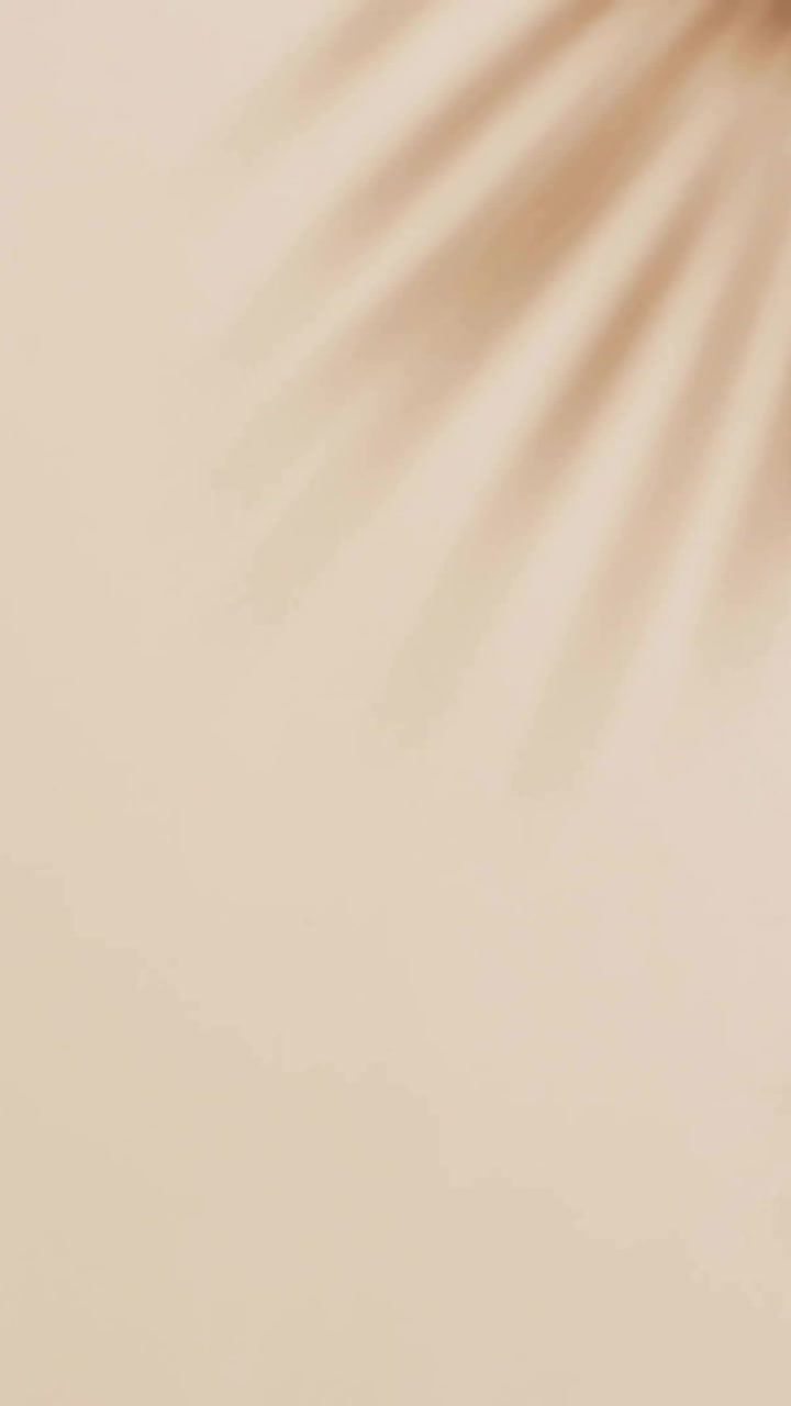 Composition of coconut halves with cocktail umbrellas over palm tree leaf on brown background