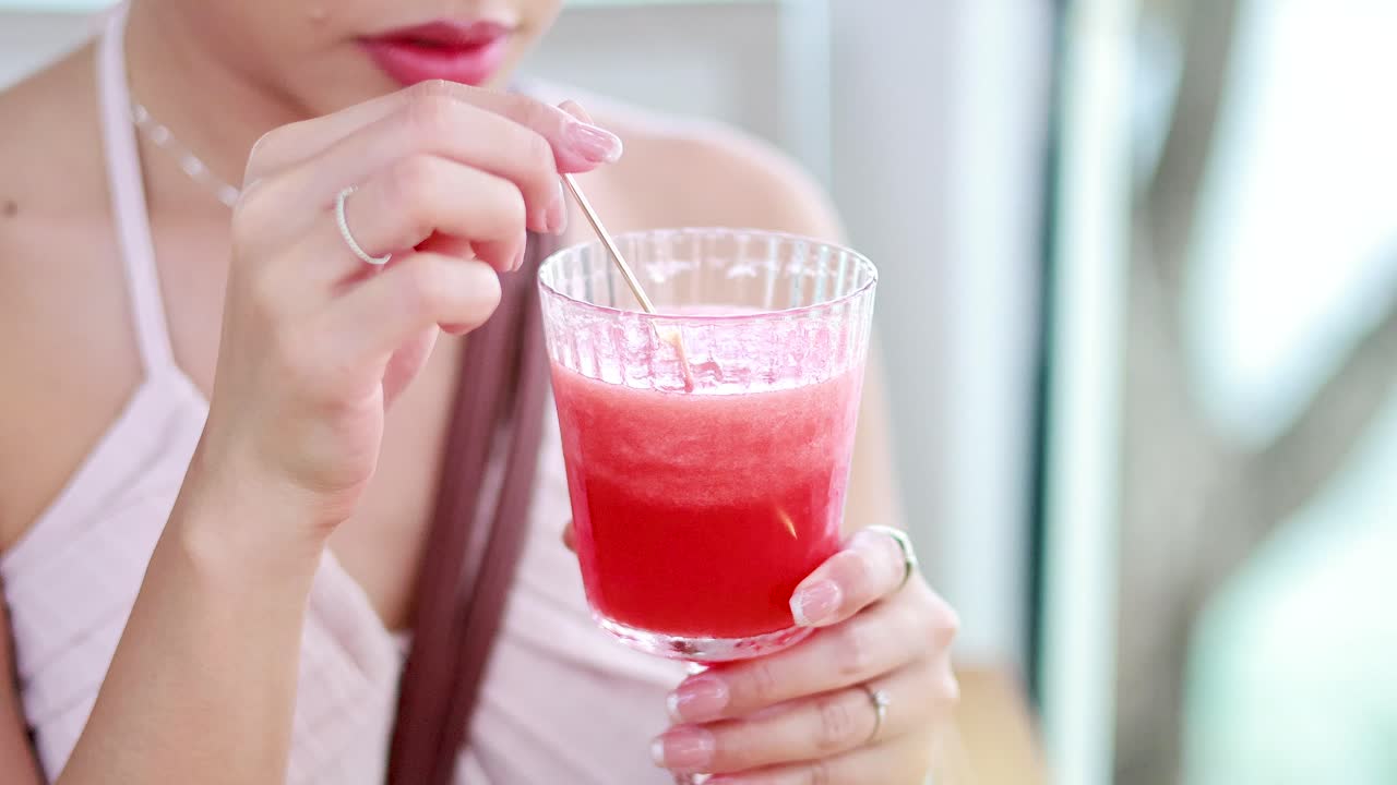Woman sipping watermelon juice with a straw