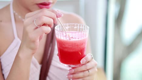 mujer bebiendo jugo de sandía con una pajita