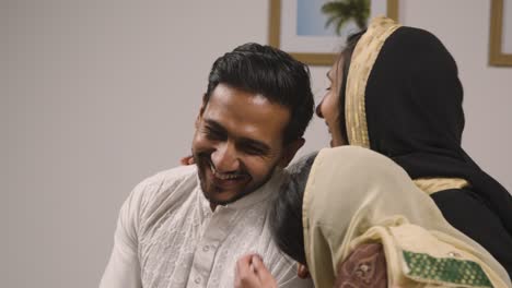 muslim family at home relaxing on sofa celebrating eid together