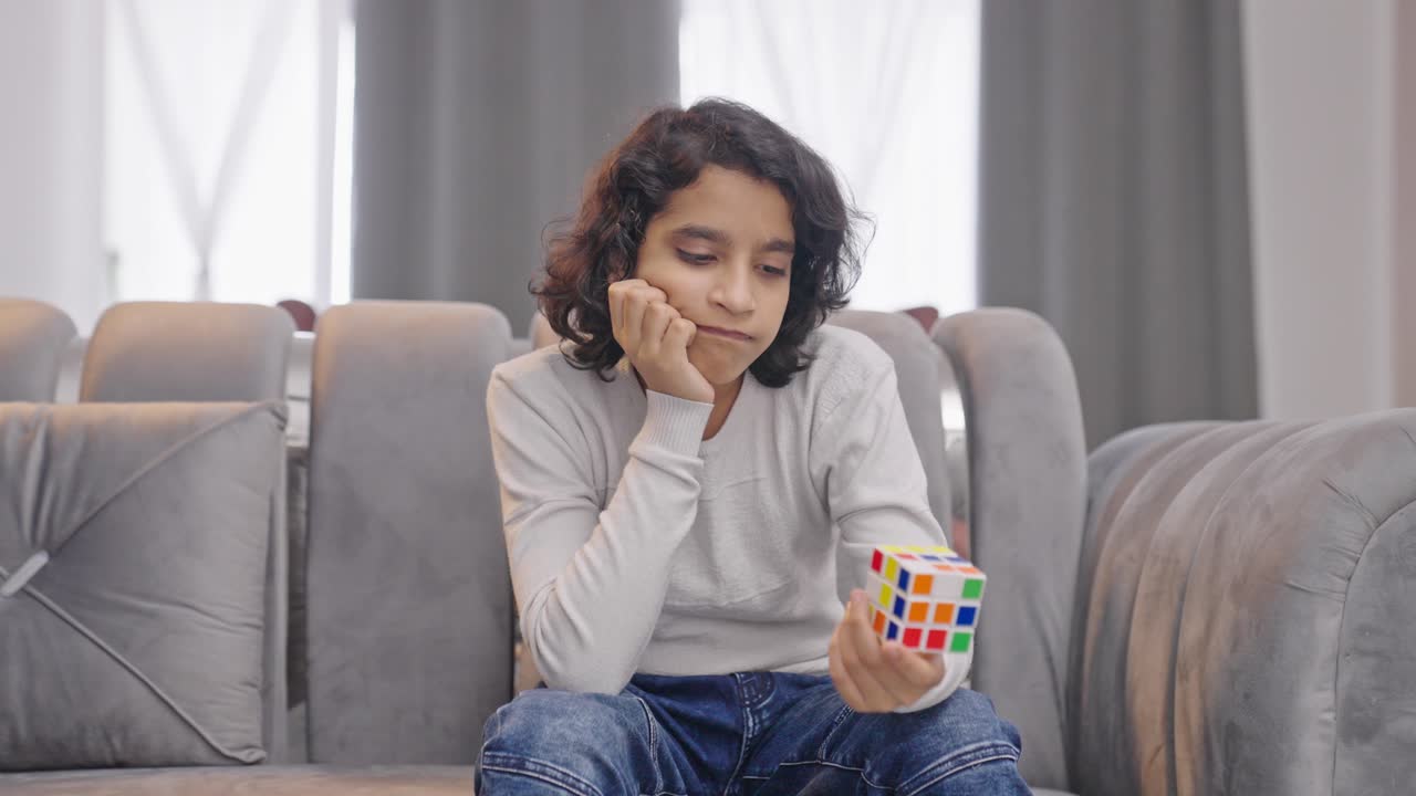 Upset Indian kid boy unable to solve Rubik's cube