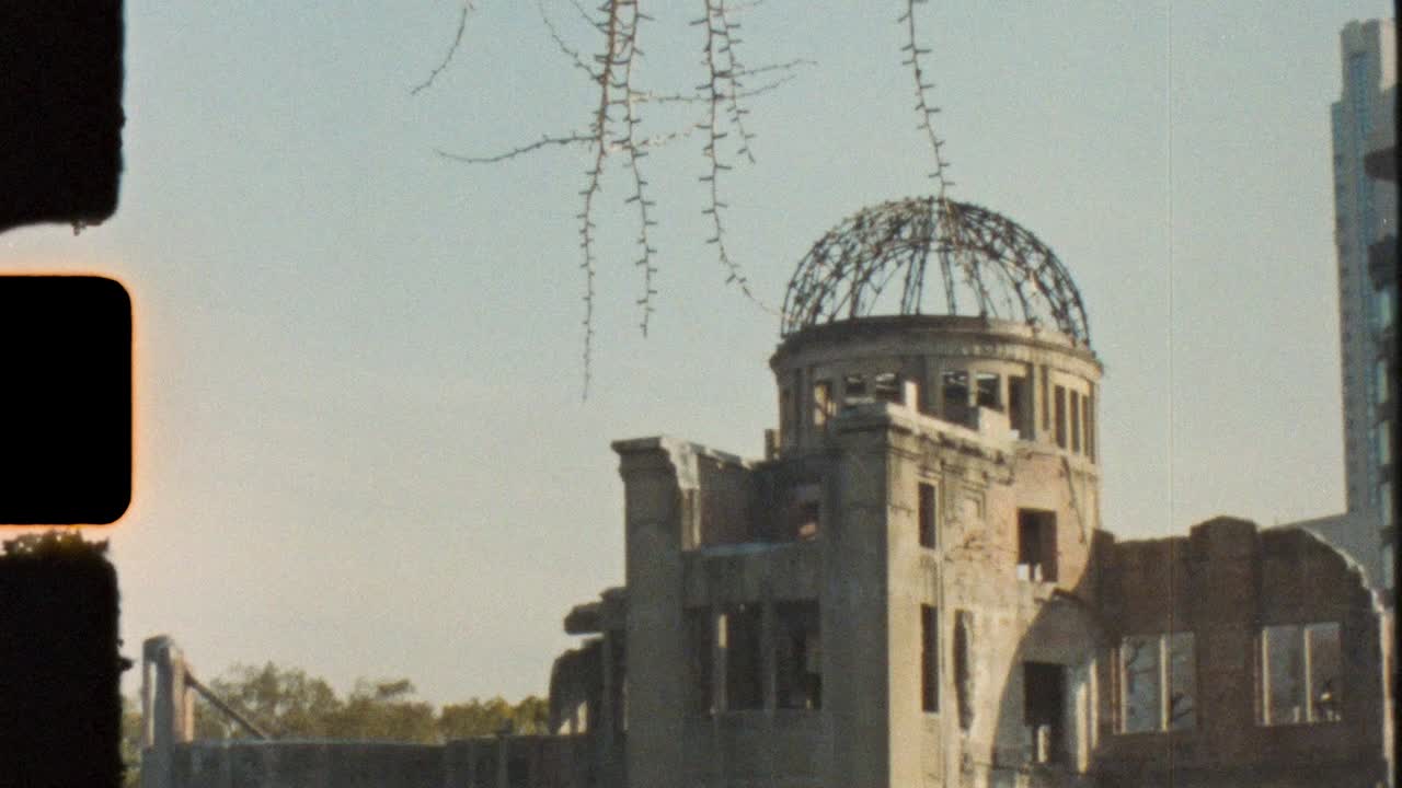Film retro vintage Super 8 mm daun-daun bergantungan di depan reruntuhan struktur Kubah Genbaku dan monumen publik bersejarah dekat Taman Peringatan Perdamaian di Hiroshima Jepang, pariwisata dan budaya Asia