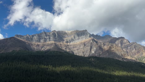 majestic mountain illuminated by sunlight, clouds passing by, banff, canada. handheld