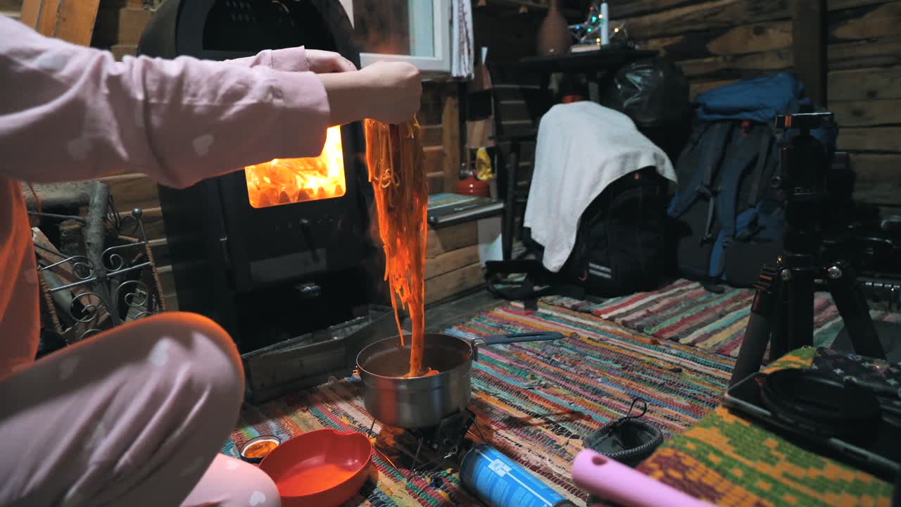 cocinar pasta con una estufa de gas portátil en una cabaña en la naturaleza, al aire libre, acampar