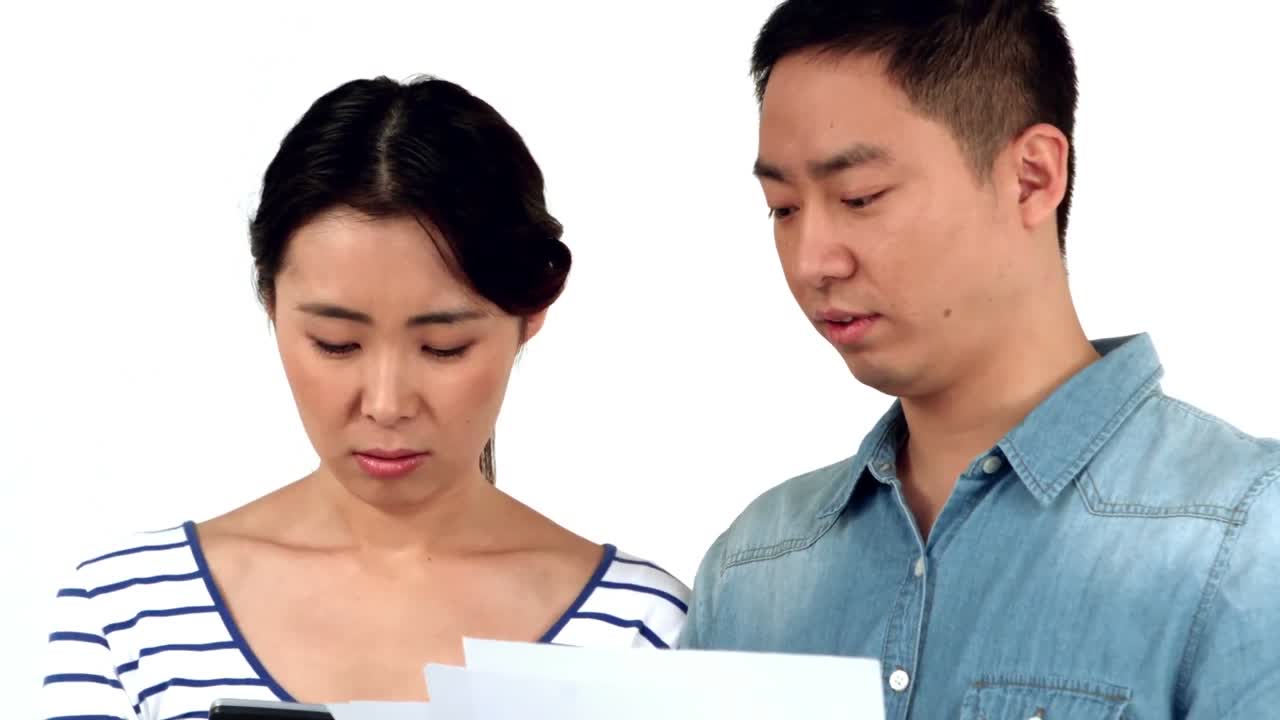 미소 짓지 않는 젊은 부부 가 회계 를 하고 있다