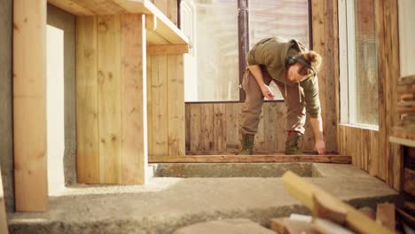 a handyman with a hammer working inside the greenhouse