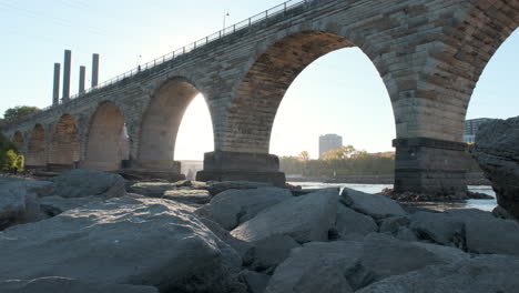 tilt-up of iconic minneapolis stone arch bridge on sunny morning