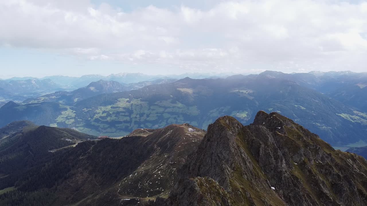 antena cinematográfica de la cima de la montaña de los alpes con una vieja capilla de madera en un pico empinado