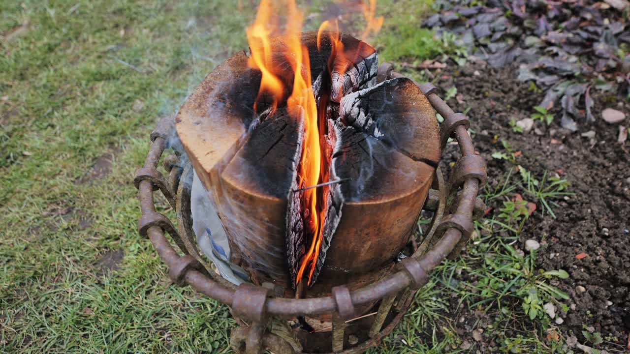Outdoor fire with Swedish torch log burning brightly in rustic Latvian backyard