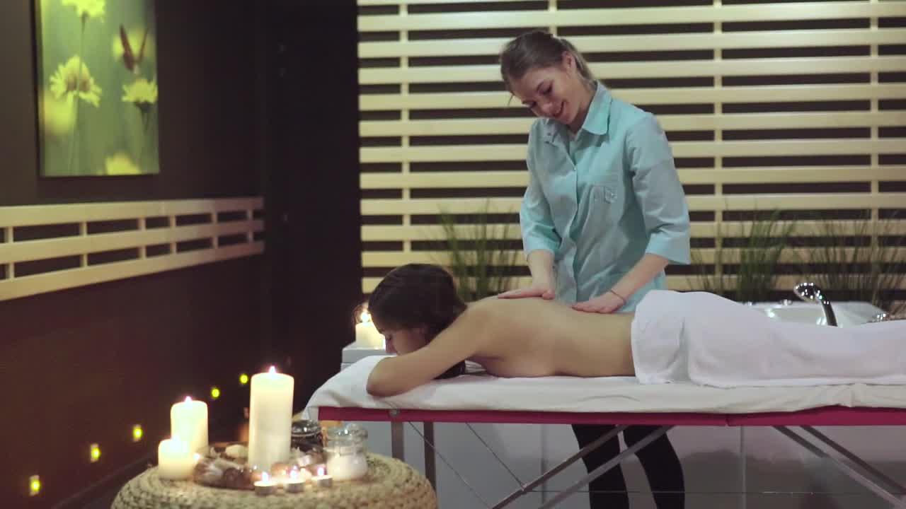 una mujer recibiendo un masaje de espalda en un spa.