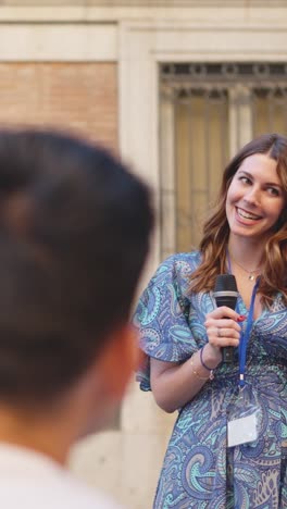 woman smiling and speaking into a microphone at an event