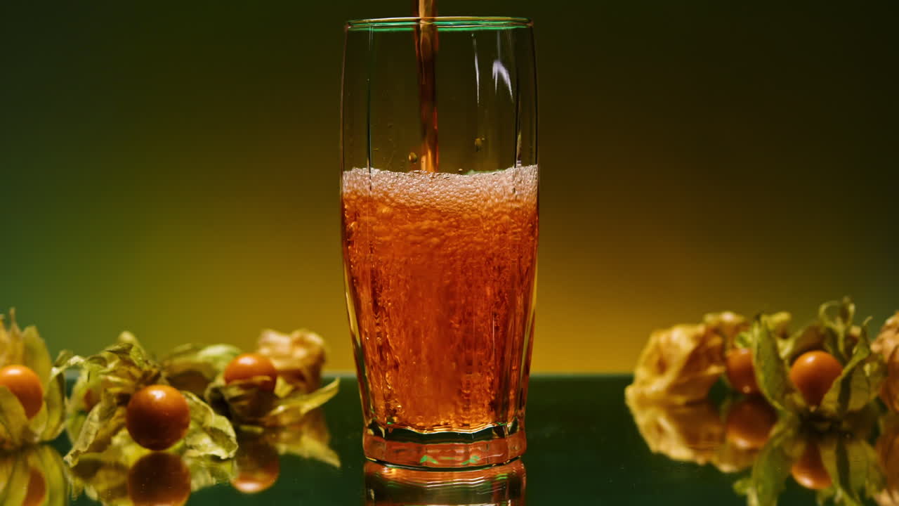 vertiendo una refrescante bebida de naranja con grosellas del cabo