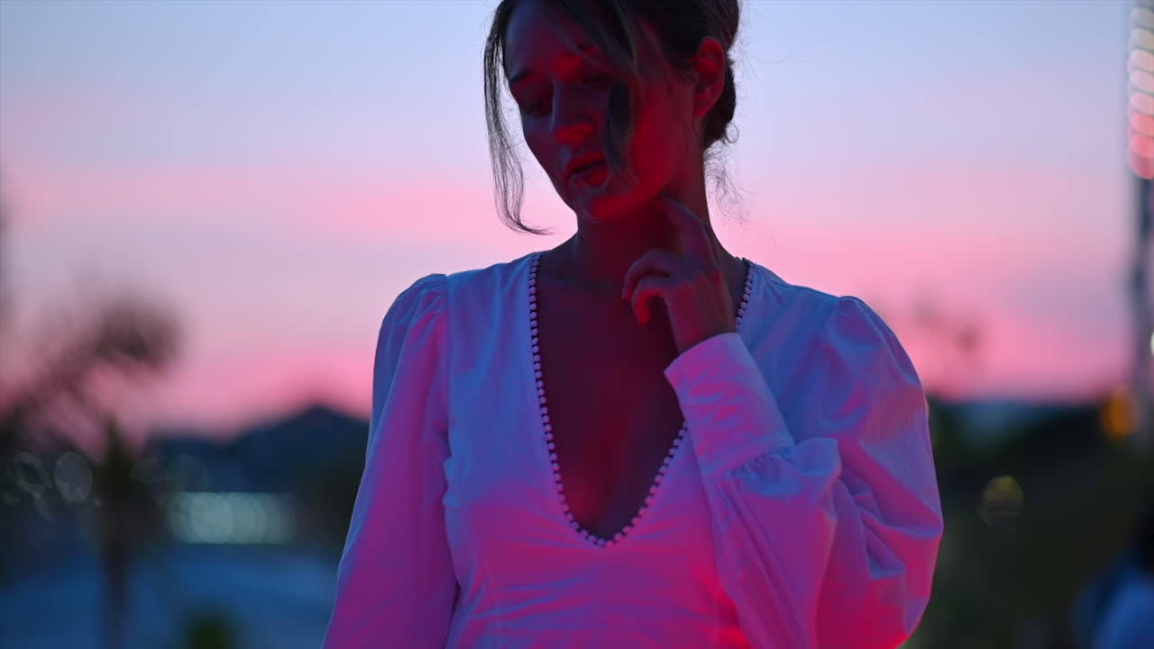 Woman in white dress walking in Cannes embankment street, France