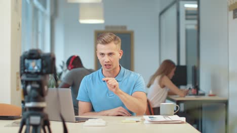 Handsome-blogger-recording-podcast.-Portrait-of-guy-sitting-in-front-of-camera.