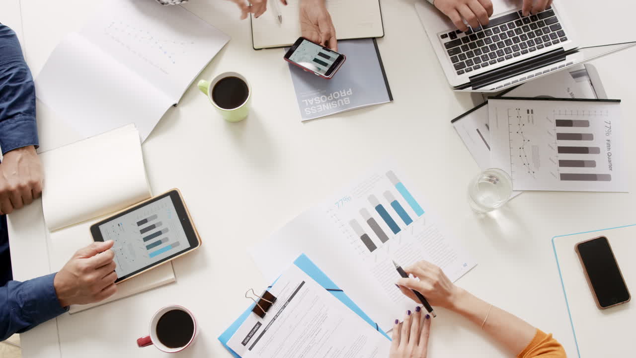 vista superior grupo de raza mixta de personas oficina pequeña empresa de inicio de empresa planificación reunión creativa utilizando tabletas digitales que muestran datos financieros y gráficos