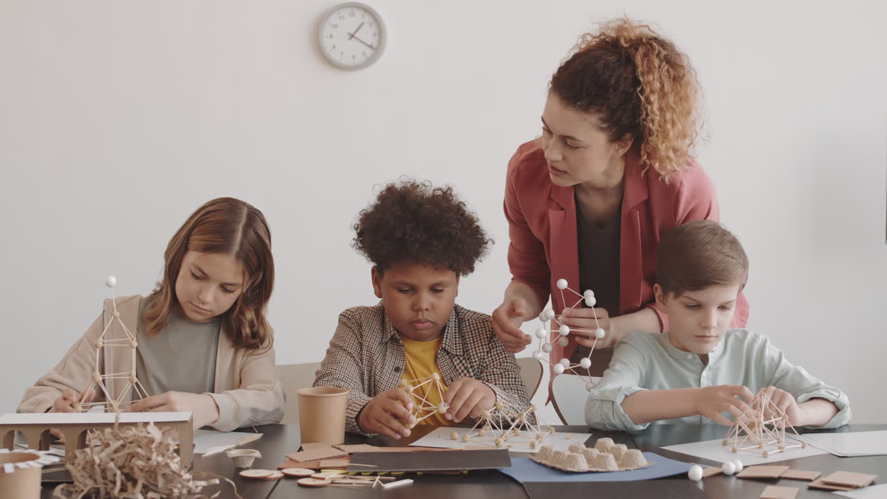 Teacher Watching Children Making Crafts