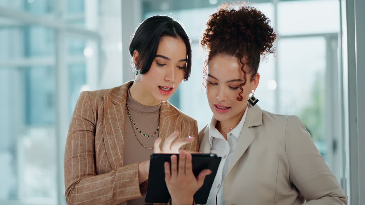 Businesswomen collaborating using a tablet in the office