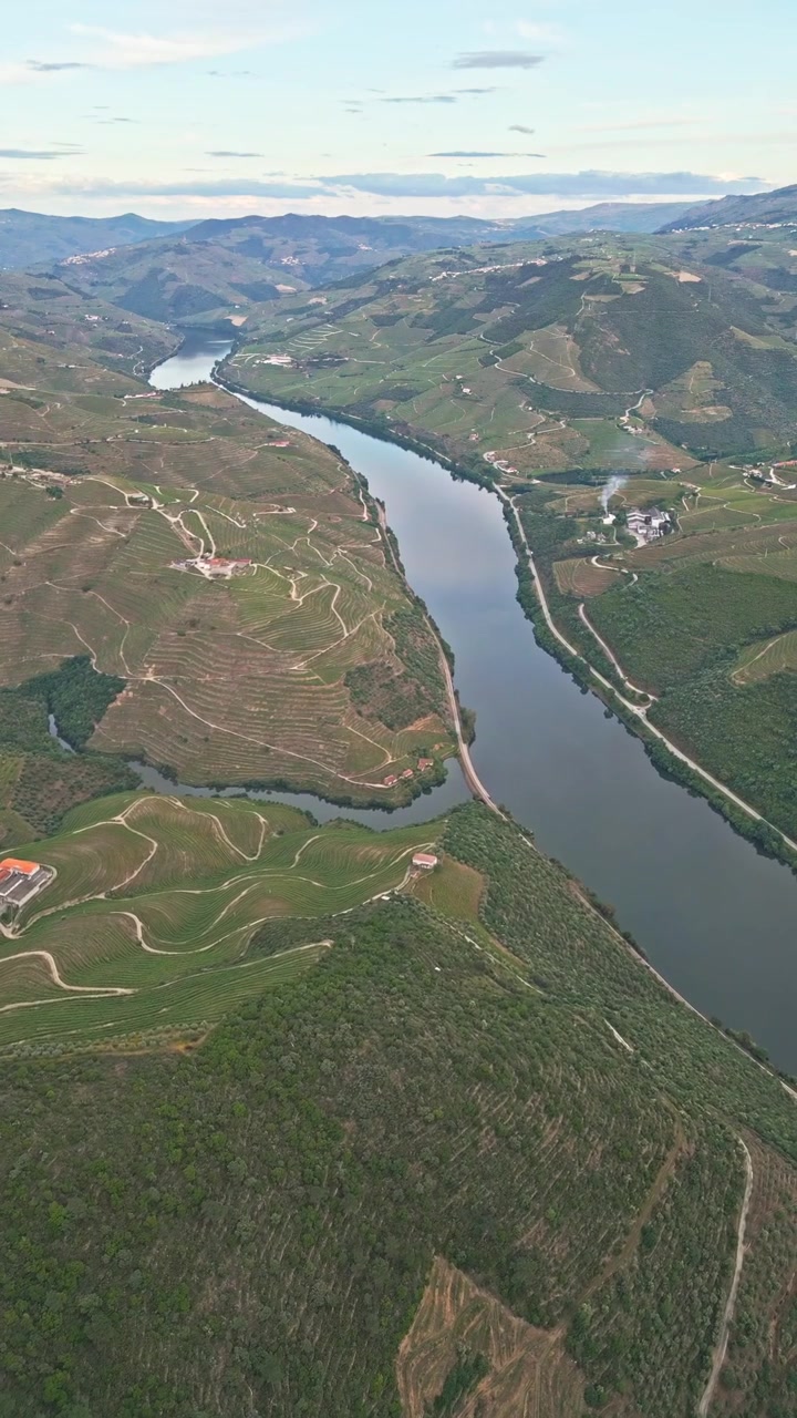 Vista aerea di un fiume serpeggiante e pendii terrazzati in una lussureggiante valle di montagna