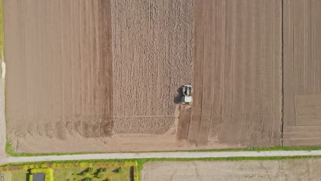 Stunning-Top-down-aerial-of-Tractor-plowing-a-plot-of-empty-land