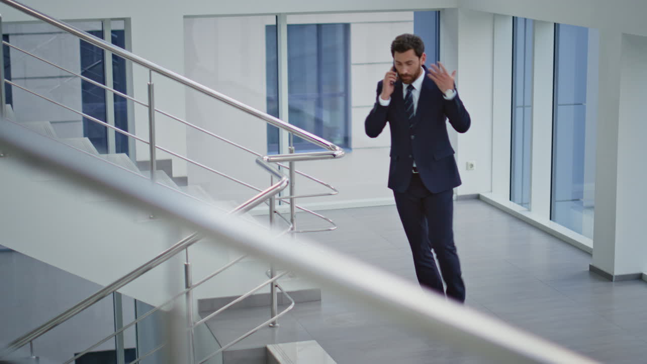 Empresário checando o relógio e ligando para o celular na escada do escritório. Executivo preocupado