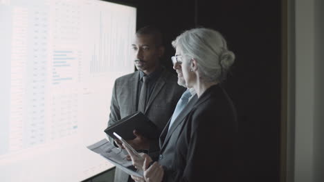 equipo de empresarios mirando la pantalla con estadísticas