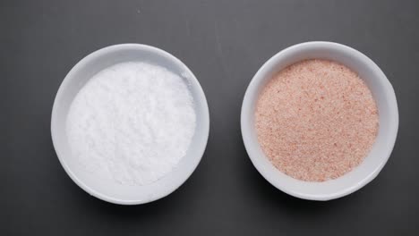 sal de himalaya rosa cruda y seca y sal blanca en la mesa,