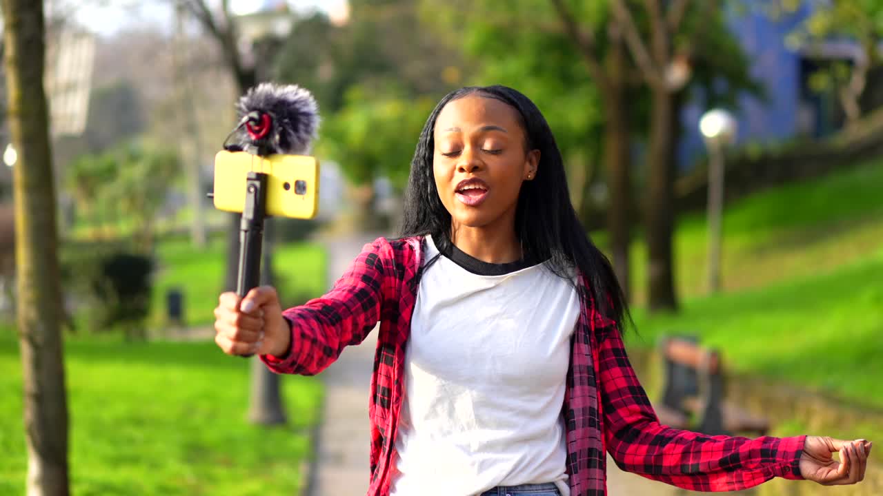 Young black woman vlogging in a park