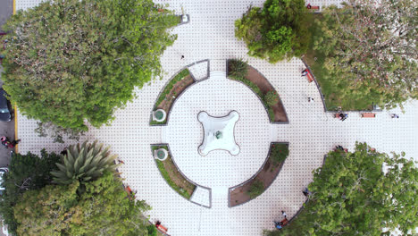 Asombroso-Y-Hermoso-Dron-Se-Aleja-De-Un-Parque-Circular-Con-árboles-En-La-Ciudad-De-Chiclayo,-Perú-Durante-El-Día