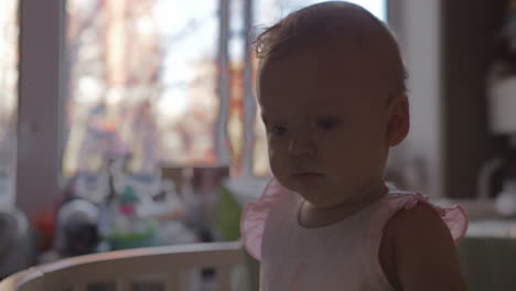 cute baby girl in a round crib 4