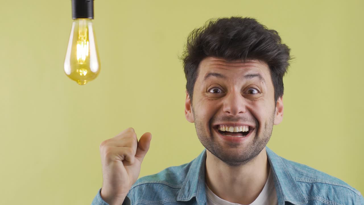 el hombre inteligente viene con nuevos inventos, ideas y la lámpara está encendida. alegría.