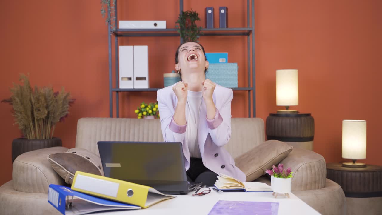 Home office worker young woman experiencing joy looking at camera.