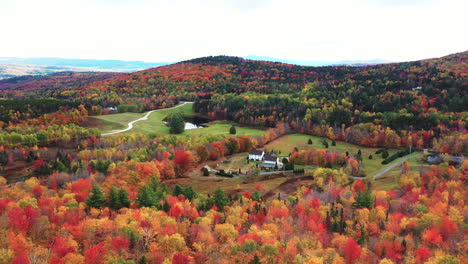 aerial view of countryside ranch mansion and colorful forest in autumn colors