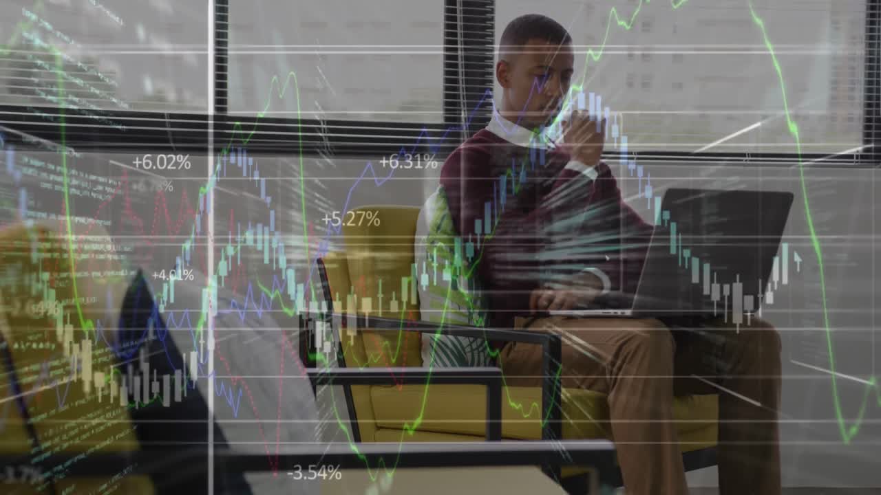Animation der Finanzdatenverarbeitung vor einem afroamerikanischen Mann, der im Büro einen Laptop benutzt.