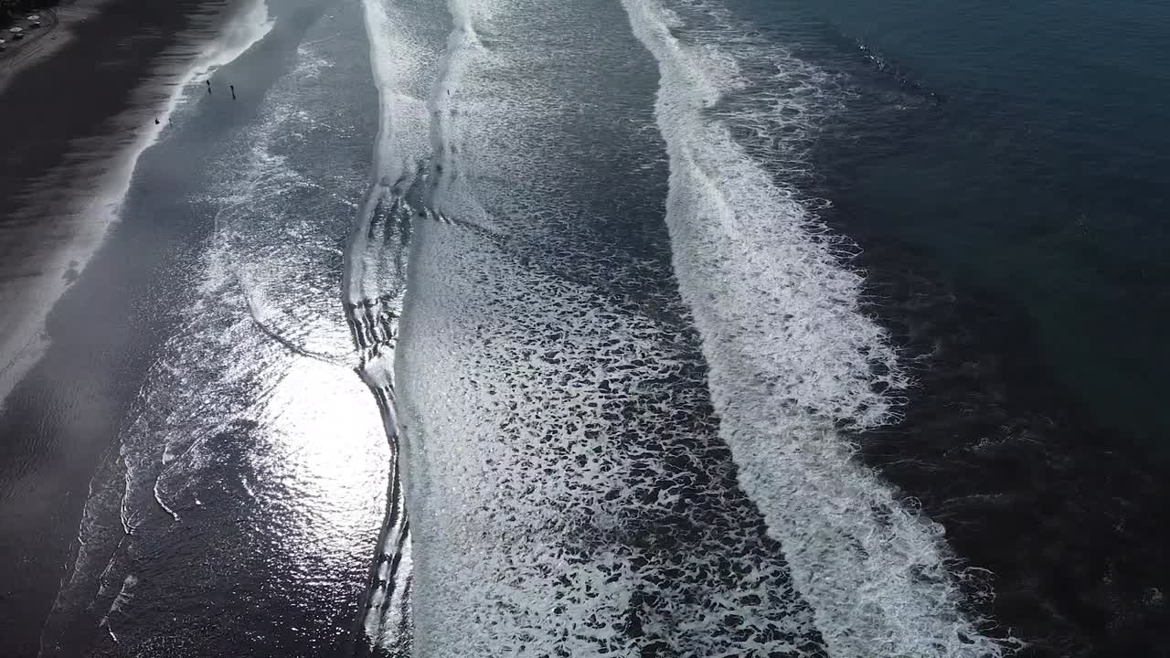Beautiful drone shot flying over the black sand beach in Jac&oacute;, Costa Rica