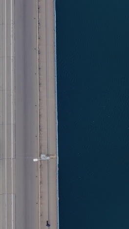 car traffic on the bridge over the river. view from the top. aerial view. vertical video